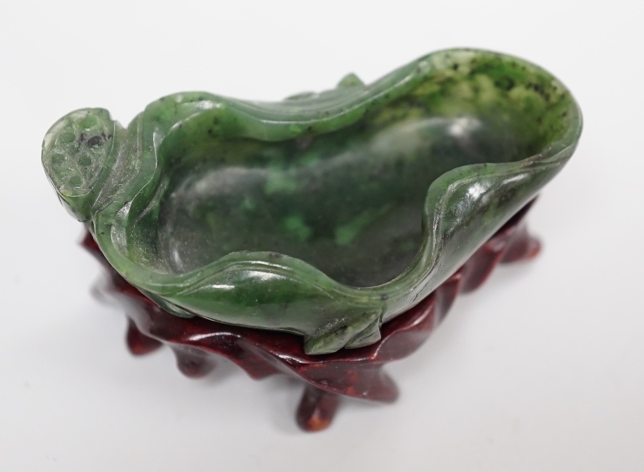 A Chinese spinach green jade 'lotus' brushwasher, 19th century, 6.8cm, wood stand
